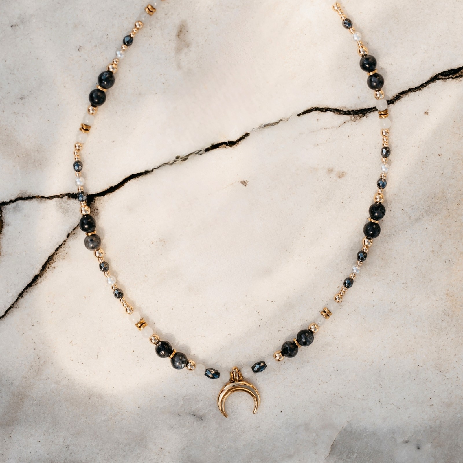 Poczuj moc natury z naszyjnikiem „Księżycowa Bogini” — labradoryt, perła i złote detale na tle spękanego kamienia